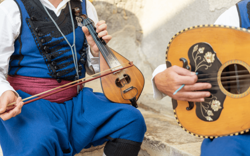 Två musiker i traditionella dräkter spelar tillsammans.